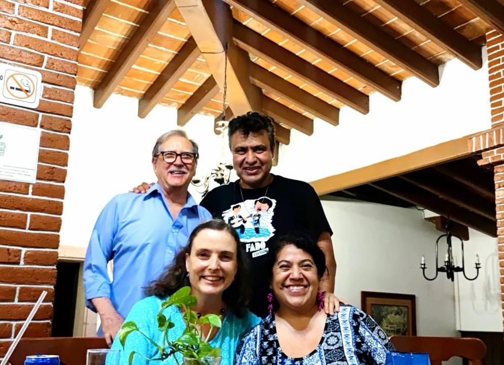 Foto de grupo de cuatro personas sonriendo en un restaurante